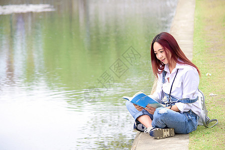 池塘边看书的长发女生背景图片