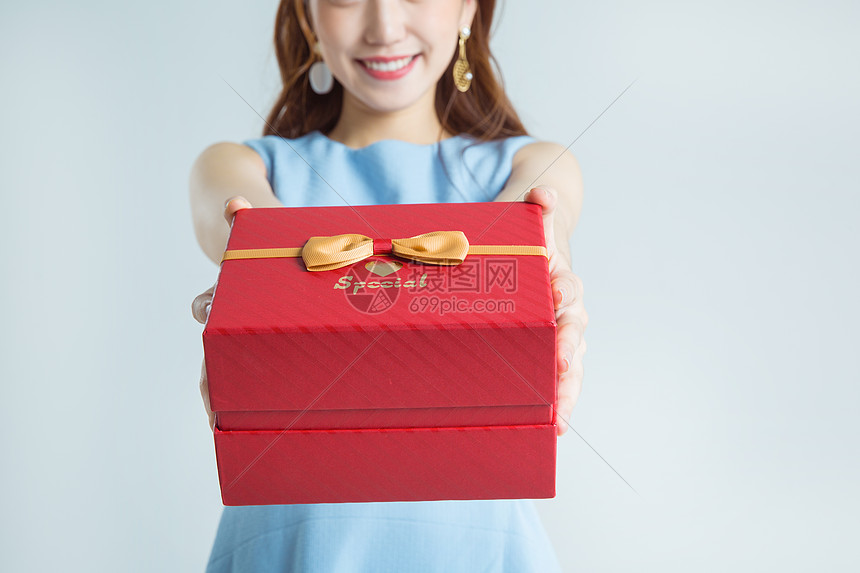 年轻女性手拿礼物盒棚拍图片