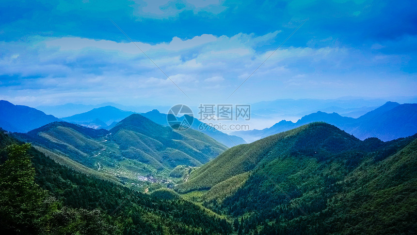 蓝天白云下的绿色山脉图片