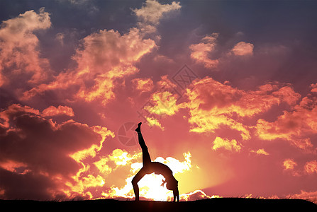 夕阳下的瑜伽女士背景图片