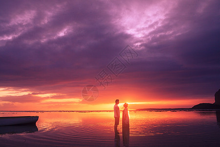 唯美海滩夕阳晚霞下的情侣背景