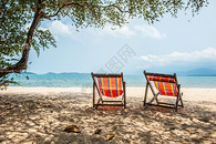 沙滩边的彩色躺椅图片