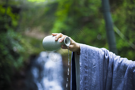 古代酒中素材手拿酒壶倒出的酒背景