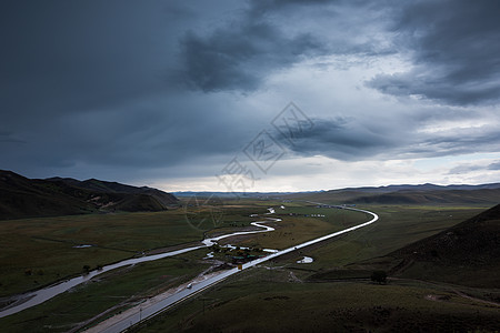 乌云滚滚乌云下的公路河流背景