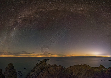 夜晚海银河苍穹下的大海和礁石背景