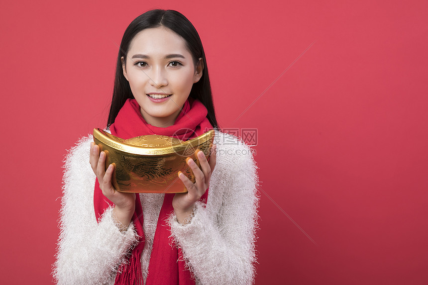 拿着金元宝的女性新年人图片