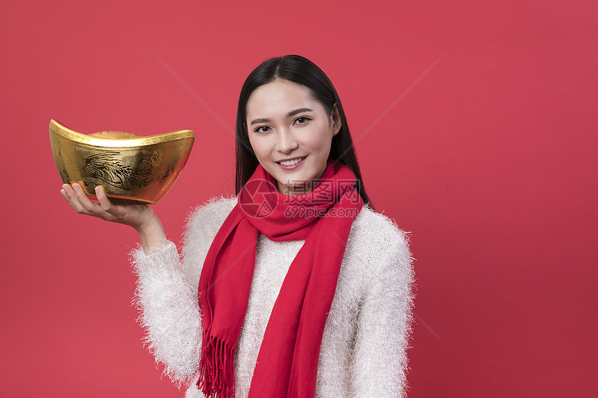 拿着金元宝的女性新年人图片