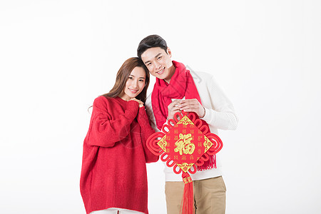 年轻夫妻拿着新年中国结背景