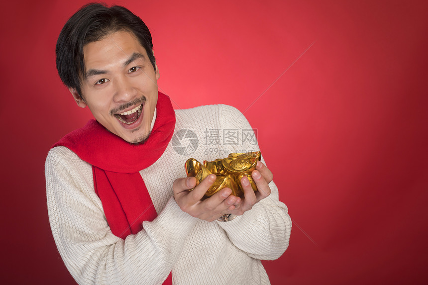 新年男士手拿金元宝图片