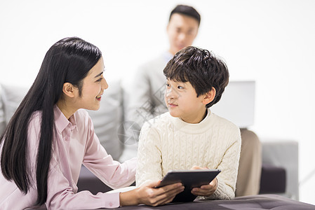 孩子平板妈妈陪儿子在客厅学习背景