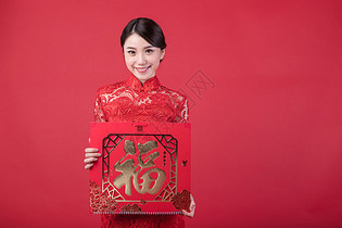 春节穿旗袍的女孩手拿福字图片