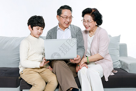 家科技老人和孙子在沙发上玩电脑背景