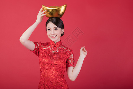 春节对联新春拿金元宝的美女背景
