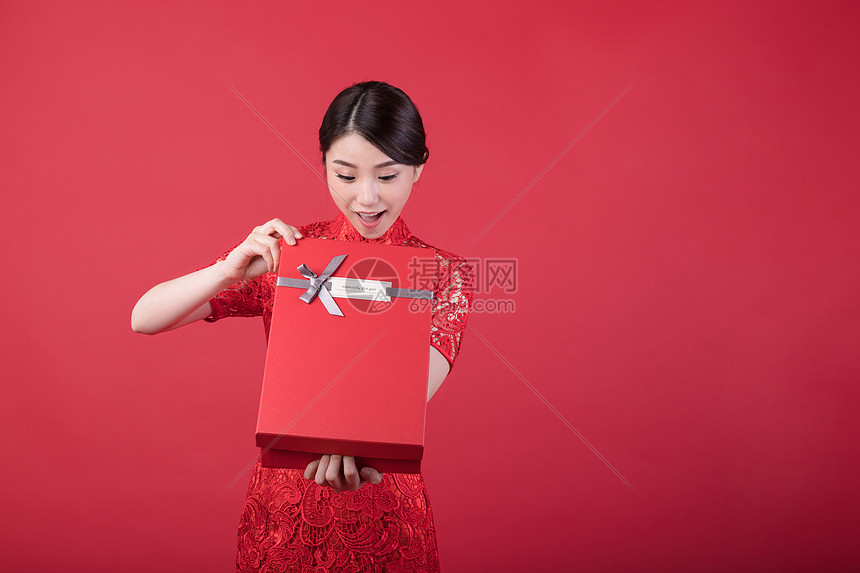 新年打开礼物的惊喜旗袍美女图片