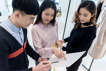 两位设计师给女顾客介绍服装背景图片