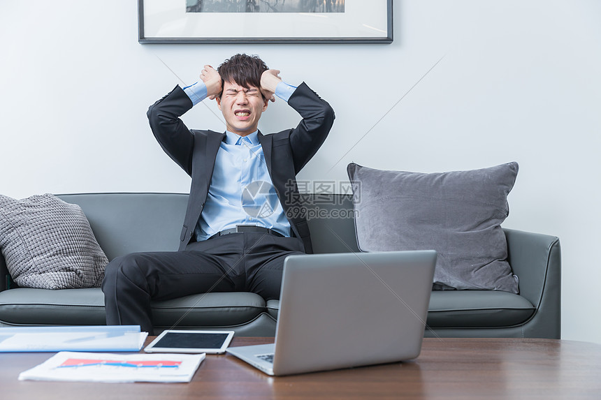 痛苦抱头的商务男士图片