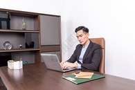 坐在办公桌前工作的商务人士图片