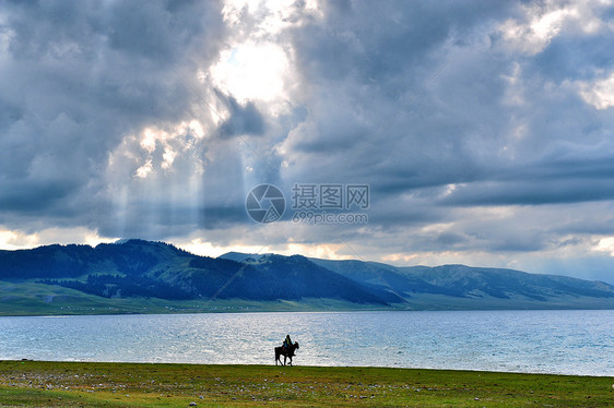 新疆赛里木湖草原羊群骑马的人图片