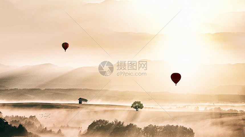 清晨阳光和白雾中的缓缓上升的热气球图片