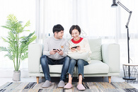 年轻情侣在客厅玩手机游戏图片