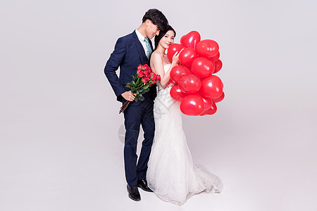 情侣婚纱手持爱心气球玫瑰花动作背景图片