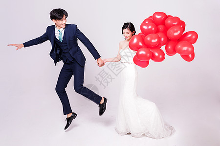 情侣婚纱持爱心气球夸张动作背景图片