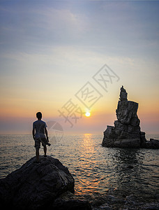 海边迎接朝阳的男性背影背景图片