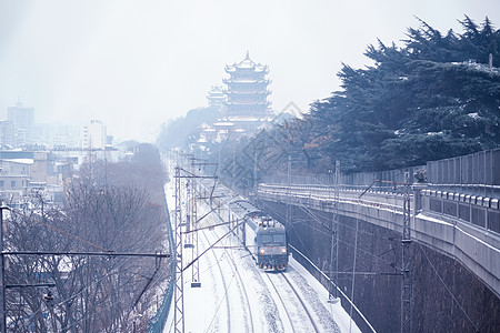 城市街拍暴雪中的黄鹤楼和火车背景