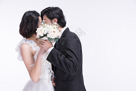 婚纱女身着西式礼服的年轻夫妻接吻背景
