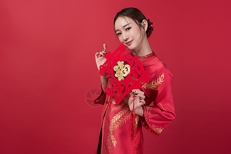 旗袍女性美妆手持中国结背景图片