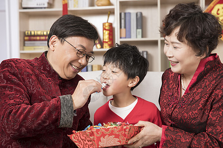 家人团聚新年爷爷奶奶给孙子喂食背景