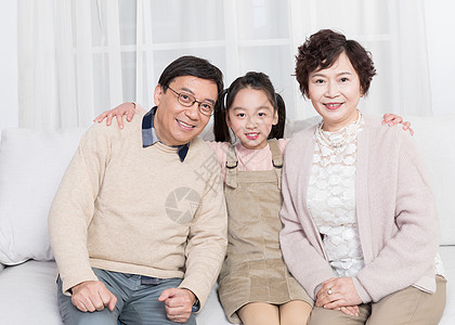 小孩子幸福地和爷爷奶奶在客厅背景图片