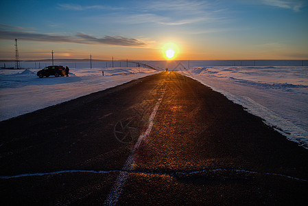 冬日日落与延伸向远方的公路背景图片