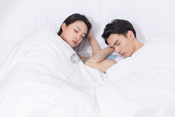 年轻夫妻拥抱躺床上休息