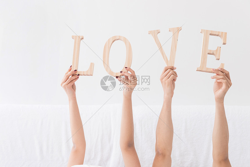 年轻夫妻躺床上手拿LOVE特写图片