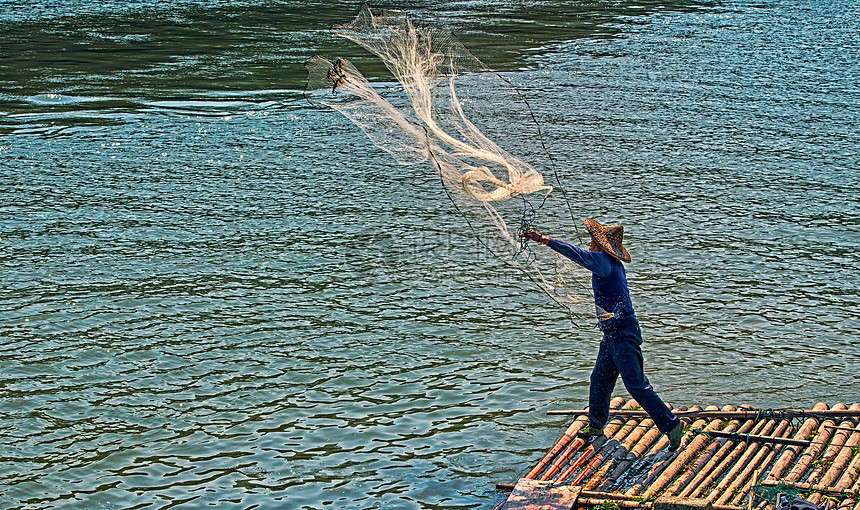 竹排上撒网的渔民图片