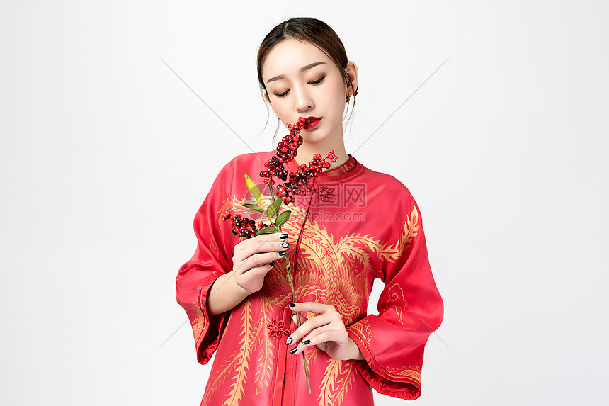 身着红装的美女手持梅花图片