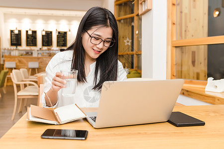 年轻女性咖啡馆内喝水图片