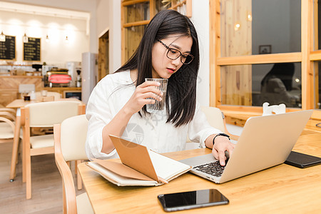 年轻女性咖啡馆内喝水图片