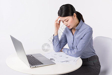 坐在办公桌前头痛的职场女性高清图片