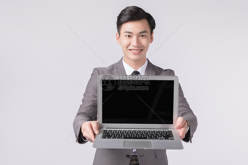 手拿笔记本电脑展示的商务人士图片