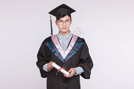 穿着学士服拿毕业证书的学生背景图片