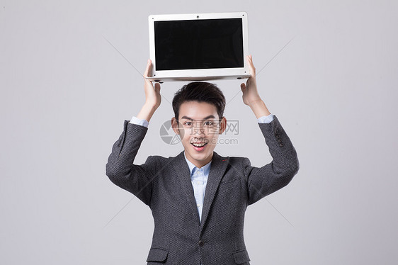 商务男性头举电脑展示图片