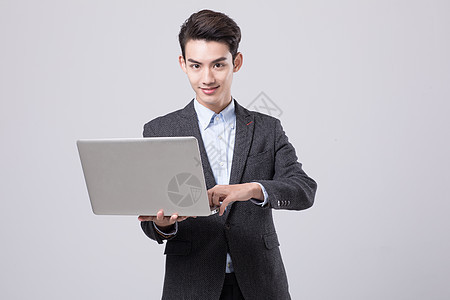 青年商务男性手拿电脑背景图片