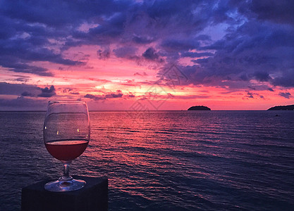 海边酒杯巴厘岛海边绚烂的火烧云日落美景背景