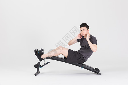 卷腹运动仰卧板上做仰卧起坐的健身男性背景
