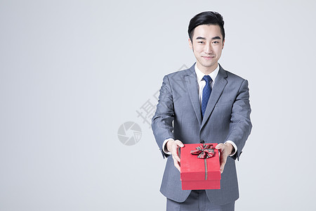商务人士礼物拿着礼物盒的商务男士背景