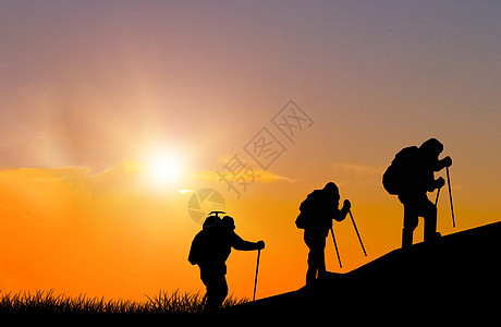 拄棍夕阳下登山剪影设计图片