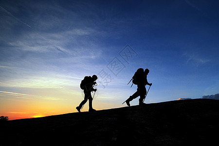 夕阳下探险者剪影背景图片