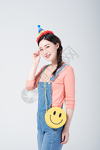 生日快乐礼物戴着生日帽微笑庆祝的青年女性背景